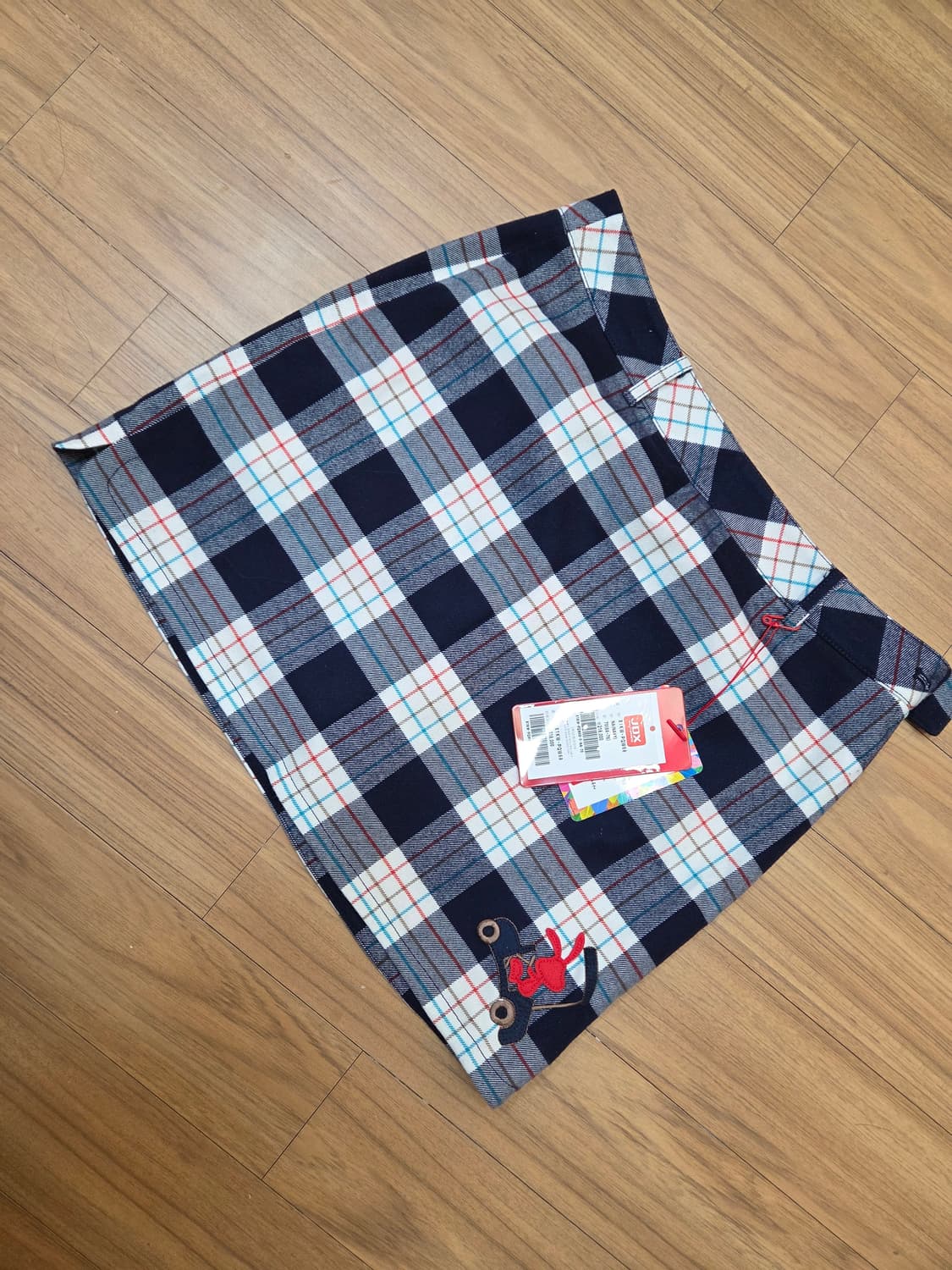 JDX 멀티스포츠 여성 골프 스커트입니다. 네이비 바탕에 흰색, 빨간색, 상품이미지1