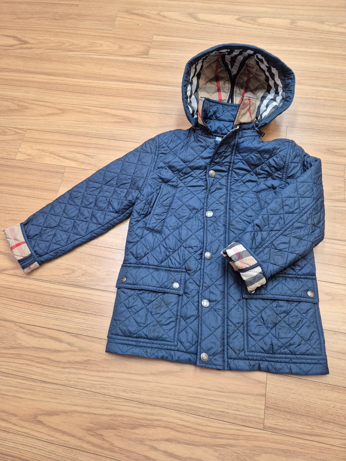 네이비 색상의 버버리 키즈 누빔 후드 자켓입니다. 겉감은 폴리아미드 소재 상품이미지1