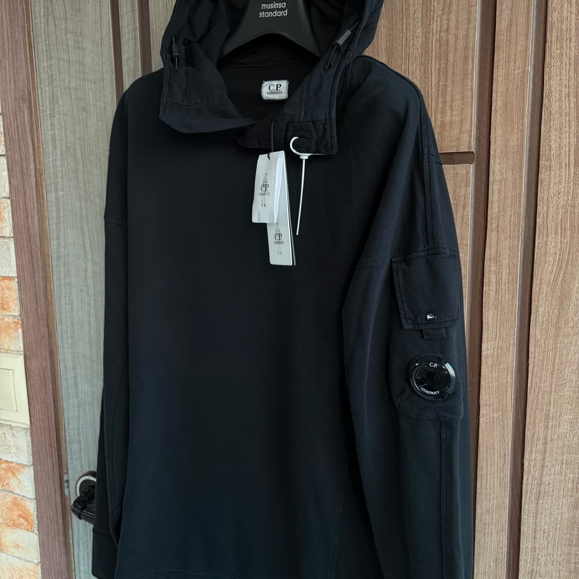 새상품(M)씨피컴퍼니 CP컴퍼니 렌즈 와펜 스탠드 후드티셔츠 블랙 상품이미지1