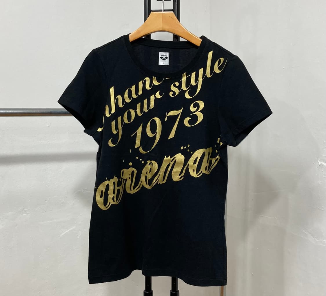 아레나(Arena) 골드 스크립트 로고 프린팅 블랙 반팔 티셔츠 상품이미지1