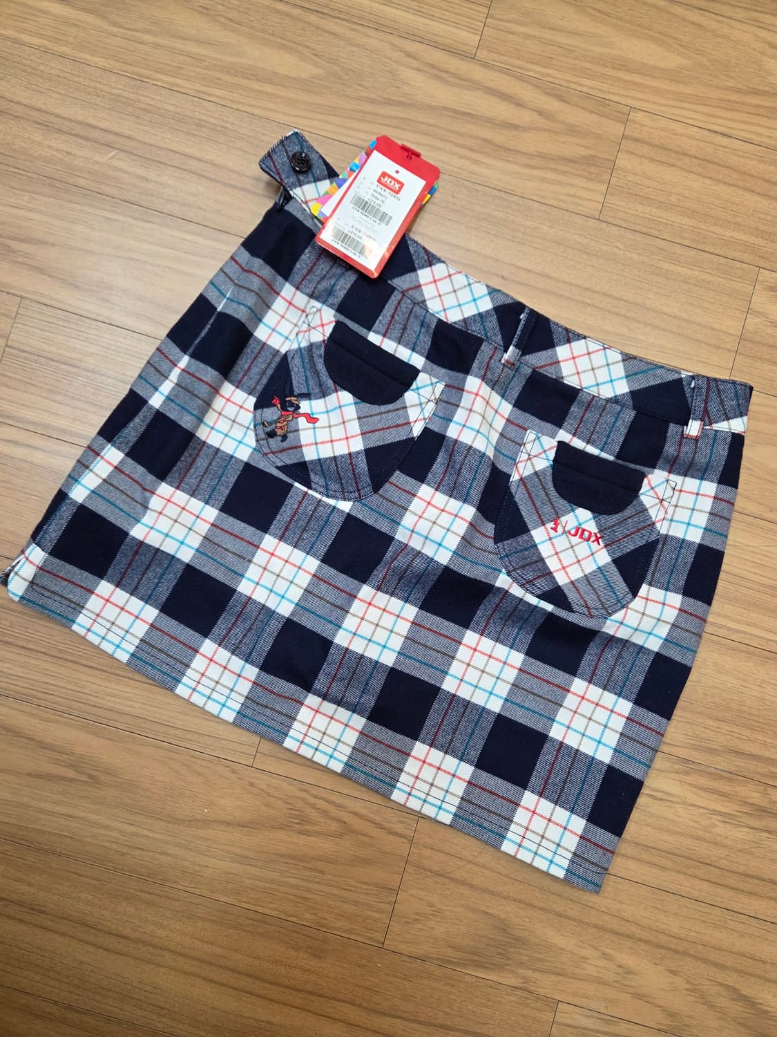 JDX 멀티스포츠 여성 골프 스커트입니다. 네이비 바탕에 흰색, 빨간색, 상품이미지2