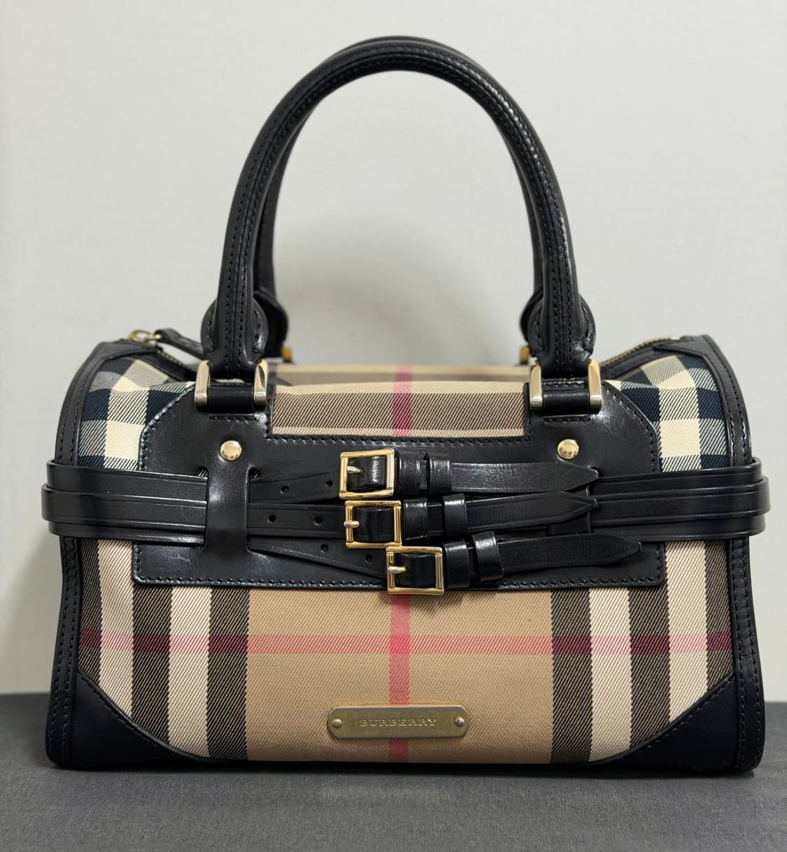 버버리 체크 패턴이 돋보이는 클래식 핸드백입니다. 상품이미지1
