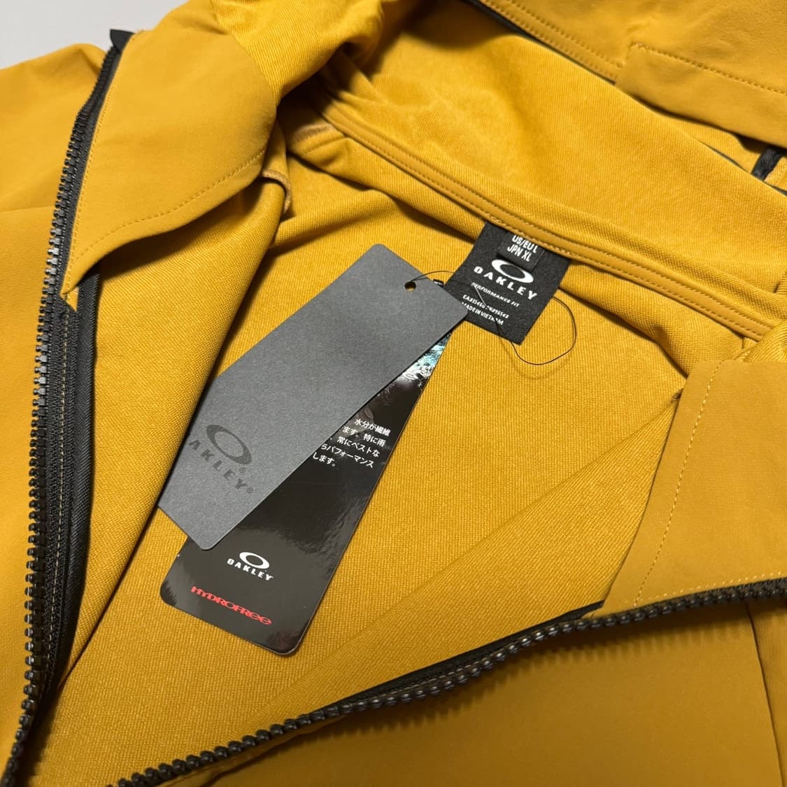오클리(OAKLEY) 머스타드 폴리아미드 엘라스테인 후드 윈드브레이커 상품이미지3