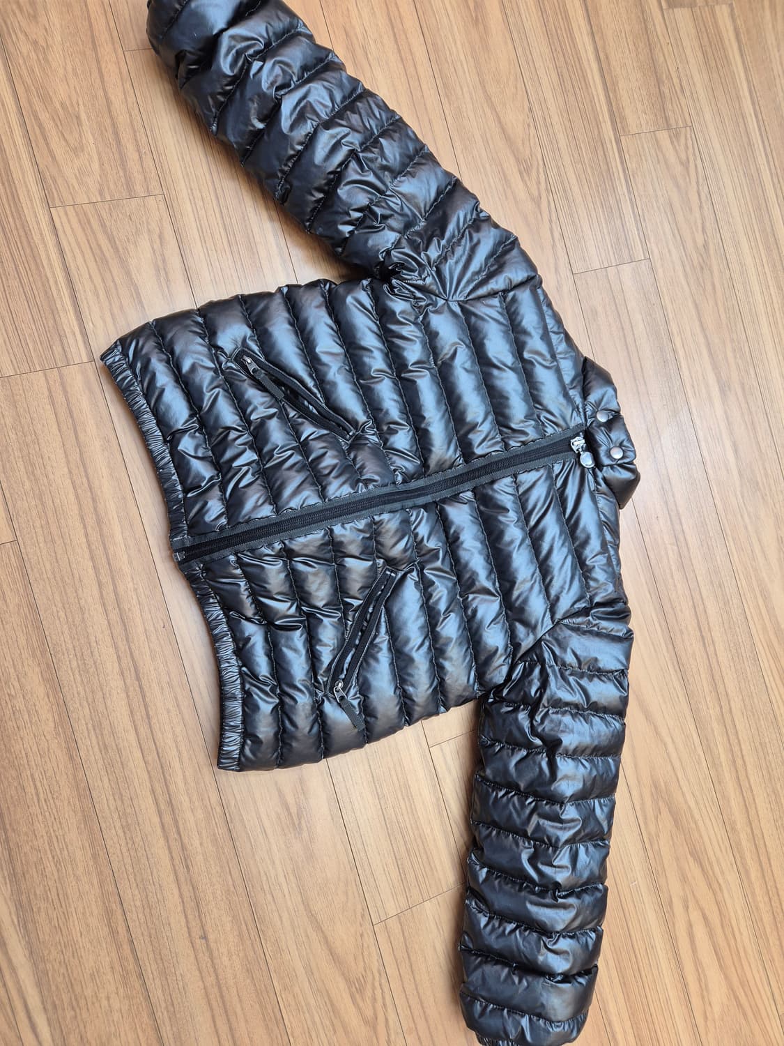 봉포인트 블랙 색상 경량 패딩입니다. 겉감은 폴리에스터 100% 소재로  상품이미지1