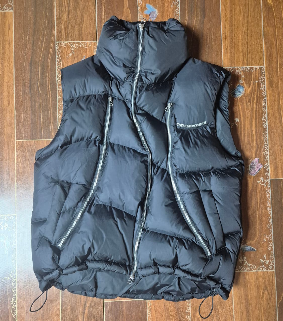 [M]더뮤지엄비지터 커브드 지퍼 패딩조끼 상품이미지1