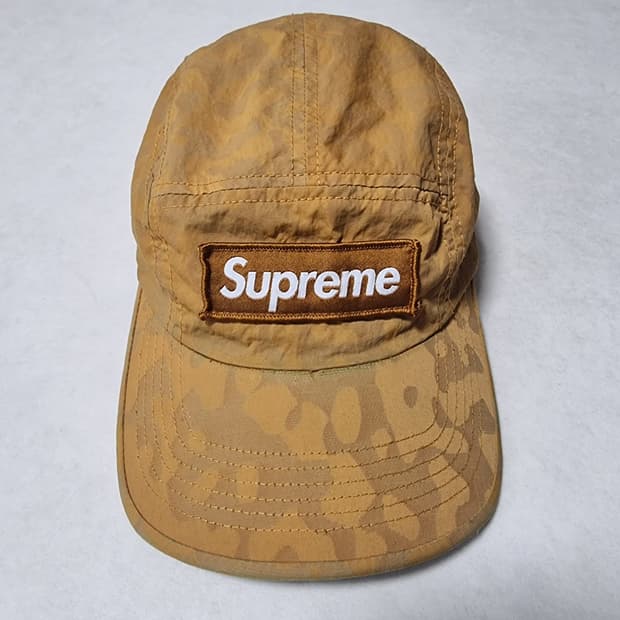 슈프림 브랜드의 카모 패턴 캠프캡