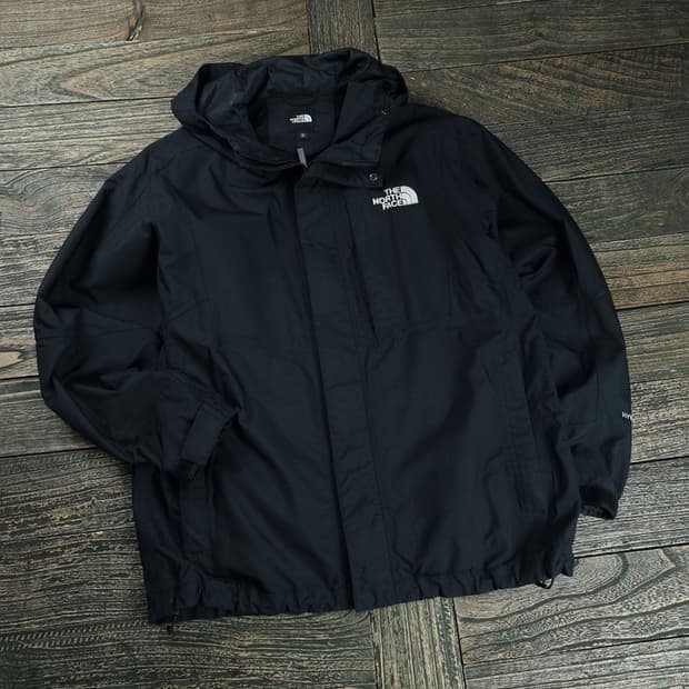 [노스페이스] 로고 자수 오버핏 후드 바람막이 자켓 블랙 M18789