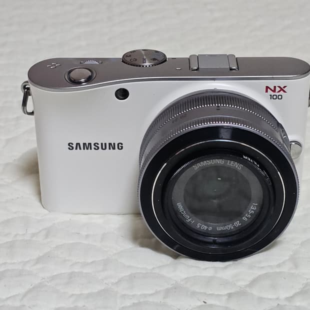 삼성 NX100 미러리스 카메라와 20-50mm 번들 렌즈 구성이에요
