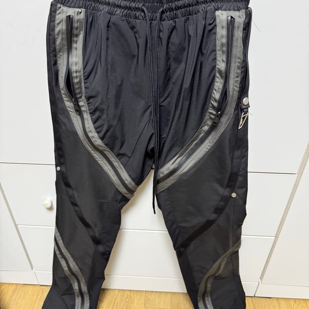 언더마이카 리전.01 트위스트 지퍼 라인 테이핑 팬츠 블랙 올리브