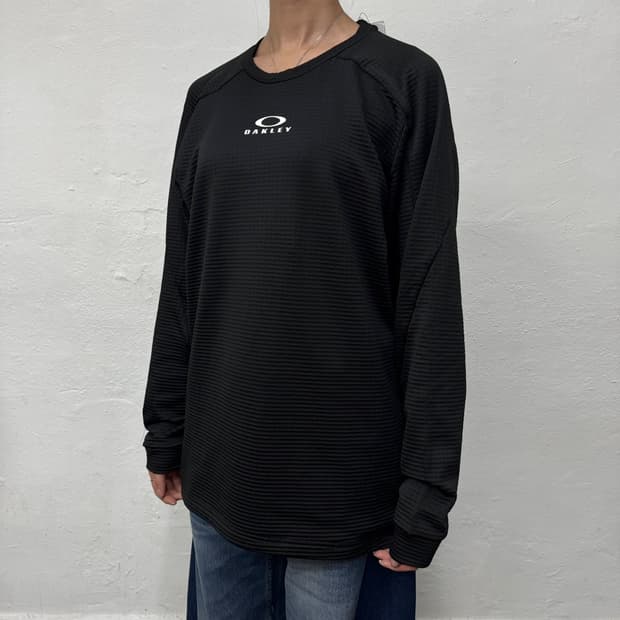 오클리(OAKLEY) 블랙컬러 서클로고 엠보싱 폴리에스터 그리드 롱슬리브