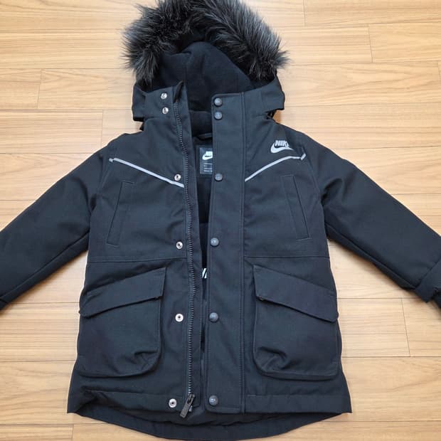 블랙 색상의 나이키 키즈 패딩 점퍼입니다. 사이즈는 110이고, 모자에 