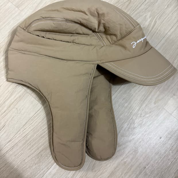  자크뮈스 라 카굴 브리치올라 퍼프 이어 플랩 햇 트루퍼햇 베이지