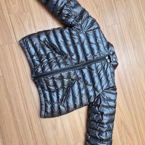 봉포인트 블랙 색상 경량 패딩입니다. 겉감은 폴리에스터 100% 소재로 