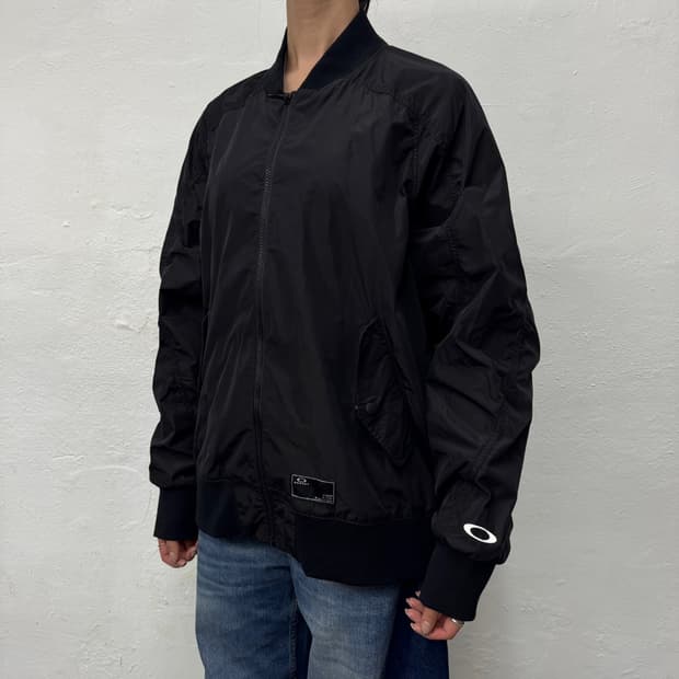 오클리(OAKLEY) 블랙컬러 폴리에스터 논칼라 쉘 윈드브레이커